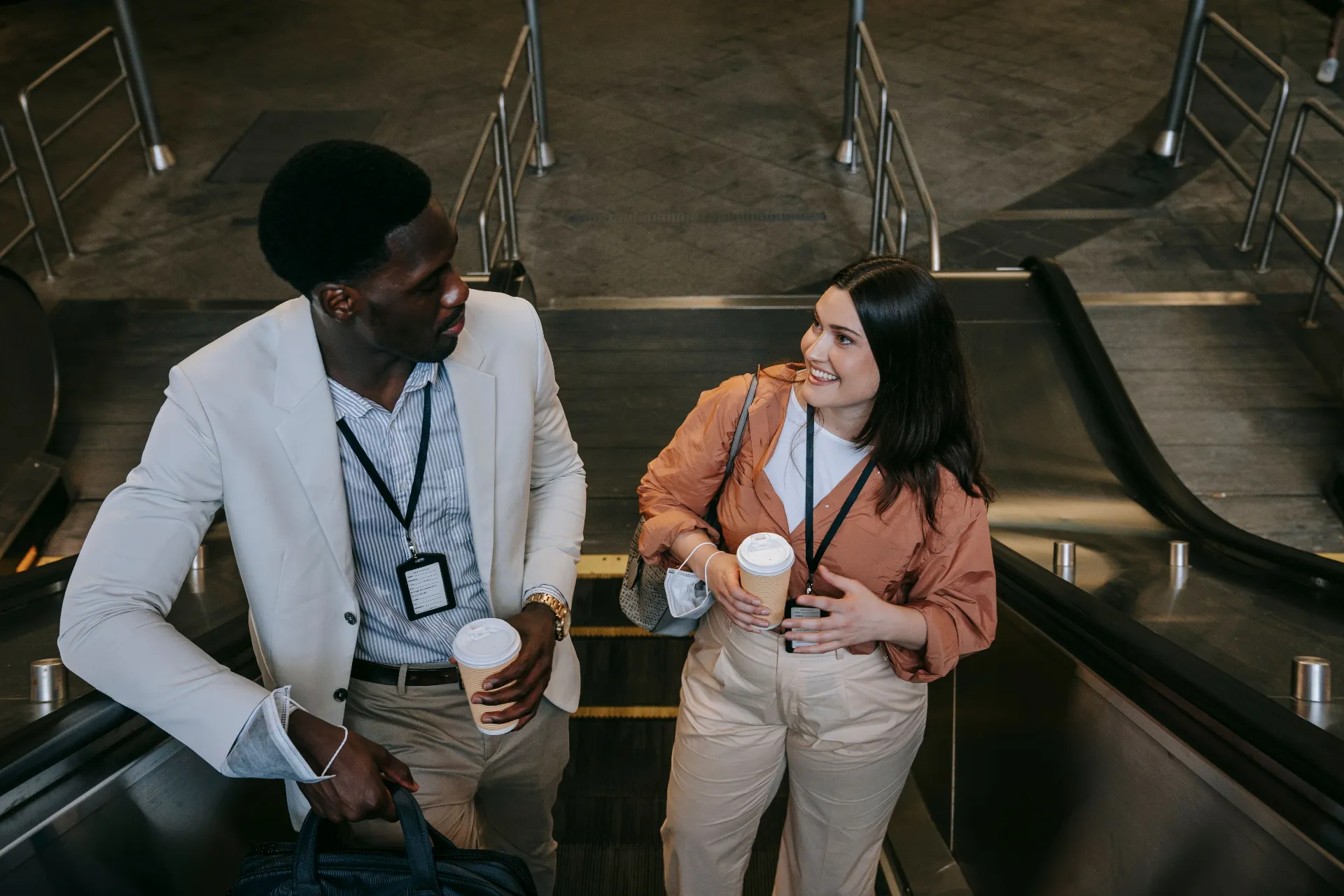 Two business professionals talking on an escalator